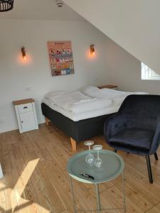 1 dormitorio con 1 cama, 1 silla y 1 mesa en Vingården i Arild, en Arild