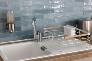 un lavandino in una cucina con una parete di mattoni blu di Cocon d'Hiver - Netflix & Wifi - Parking Gratuit - check-in 24H24 - Kit Bébé disponible sur demande - Emplacement Vélos - GoodMarning a Chalons en Champagne Altre 35 foto