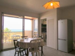 a kitchen and dining room with a table and a refrigerator at Appartement face Mer, idéal famille 6NOUM12 sea view 2 bedrooms apartment in Canet-en-Roussillon