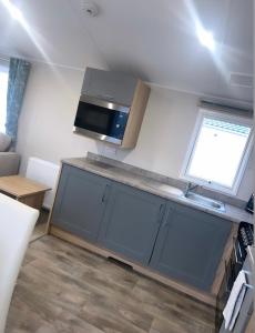 a small kitchen with a counter and a window at Brand New Modern Holiday Home - Haven The Orchards Holiday Park in Saint Osyth