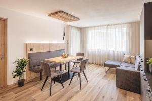 a living room with a table and chairs and a couch at Apartments Silva Timeout in San Giovanni in Val Aurina
