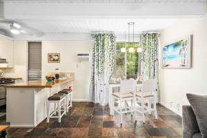 a kitchen and dining room with a table and chairs at Kona Mansions by Casago Kona - Condo C-108 in Kailua-Kona