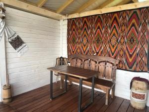 a wooden table and a bench in a cabin at Мелодія Гір Вид на гори in Vorokhta