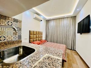een badkamer met een wastafel en een bed in een kamer bij DAR EL CADI -Quaa Assrasse- in Kaa Asras