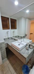 uma casa de banho com um lavatório e um espelho grande em JATIÚCA SUITES RESORT - FLAT VISTA MAR em Maceió