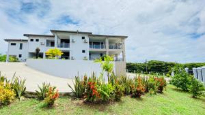 a white house with flowers in front of it at Lovely 4-bedroom Holiday home with free parking. in Lautoka