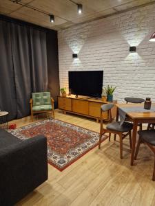 a living room with a tv and a table and chairs at Apartamenty LOFTykocin in Tykocin