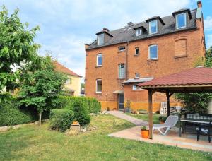 a large brick building with a gazebo in a yard at Apartment Bayreuth, Große Ferienwohnung im Haus mit Kunst, 3 Schlafzimmer, Küche, Parkplatz in Bayreuth