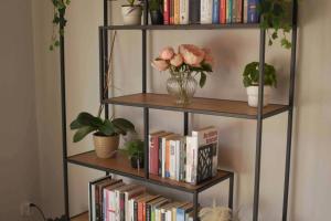 a book shelf with books and flowers on it at Leben an der Ems. in Rheine