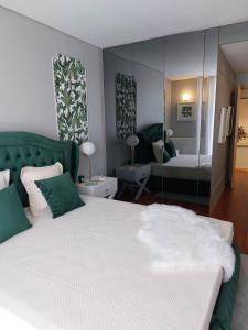 1 dormitorio con 1 cama grande y espejo en Appartement en face de la mer, en Azurara