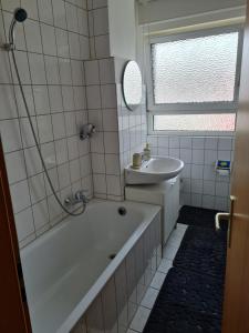 La salle de bains est pourvue d'une baignoire blanche et d'un lavabo. dans l'établissement Wohnung in Herne, à Herne