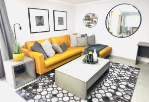 a living room with a yellow couch and a table at Lemon Ivy Guesthouse in Polokwane