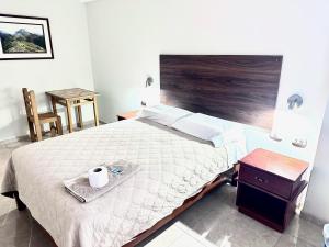 um quarto com uma cama grande e uma cabeceira em madeira em HOTEL DORADO AREQUIPA em La Apacheta
