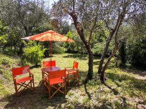 einen Tisch mit vier Stühlen und einem Sonnenschirm in der Unterkunft La scala di Ba in Castiglione Chiavarese