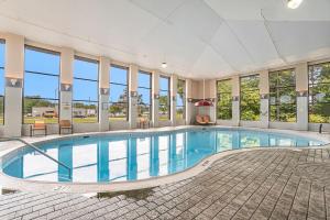 a swimming pool in a large building with windows at Baymont by Wyndham Grand Haven in Grand Haven