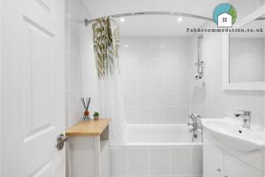 a white bathroom with a tub and a sink at Central Apt-2Bed 2Bath-AC unit-By FabAccommodation in Bristol