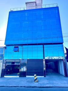 um edifício de vidro azul com estacionamento em HOTEL DORADO AREQUIPA em La Apacheta