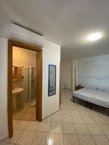 a bedroom with a bed and a bathroom with a sink at Lecce Rooms in Castro di Lecce