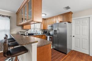 a kitchen with wooden cabinets and a stainless steel refrigerator at Villa Florentina. in Clearwater