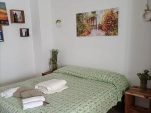 una camera da letto con un letto verde e asciugamani di Curte Verde a Montesano Salentino