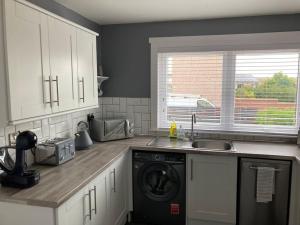 a kitchen with a sink and a washing machine at Haymons Cove in Eyemouth