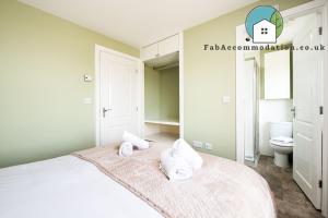 En eller flere senge i et værelse på Large 3Bed-Parking & Garden-By FabAccommodation