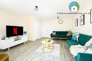 a living room with a green couch and a tv at Large 3Bed-Parking & Garden-By FabAccommodation in Bristol