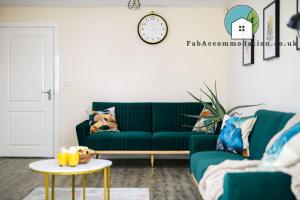 a living room with a green couch and a table at Large 3Bed-Parking & Garden-By FabAccommodation in Bristol