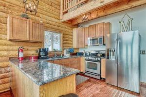 a kitchen with wooden cabinets and a stainless steel refrigerator at Spectacular Chalet overlooking the ski slopes in Brian Head