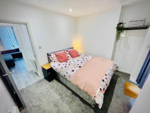 a bedroom with a bed with two red pillows at New Modern Apartment With FREE Private Parking in Plymouth