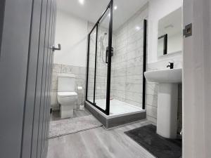 a bathroom with a toilet and a sink and a shower at New Modern Apartment With FREE Private Parking in Plymouth +30 photos