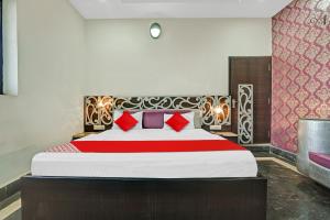 a bedroom with a large bed with red pillows at Flagship Hotel Pragya 4 in Raipur