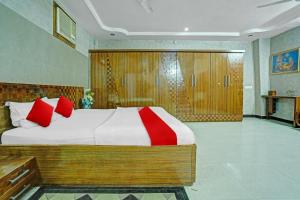 a bedroom with a large bed with red pillows at Flagship Hotel Pragya 4 in Raipur