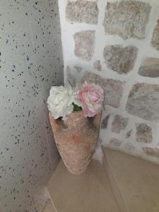 a vase with flowers in the corner of a wall at Guest House Kormilo in Ston