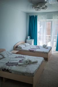 Del Mar Koblevo في كوبليفو: غرفة نوم بسريرين عليها مناشف