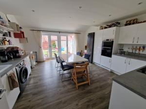 a kitchen with a table and chairs in a room at Spacious 3 bedroom family home in Shinfield