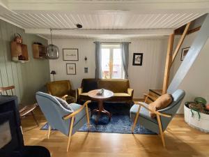 uma sala de estar com cadeiras e uma mesa em Stamsund Authentic Rorbu em Stamsund