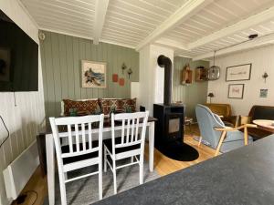 a kitchen and living room with a table and chairs at Stamsund Authentic Rorbu in Stamsund