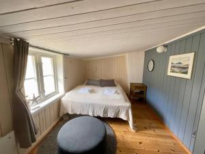 a small bedroom with a bed and a window at Stamsund Authentic Rorbu in Stamsund