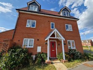 a red brick house with a red door at Spacious 3 bedroom family home in Shinfield