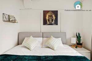 - un lit avec des draps et des oreillers blancs dans une chambre dans l'établissement Private 2Bed-Parking & Garden-By FabAccommodation, à Bristol