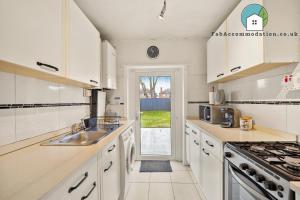 a kitchen with white cabinets and a sink at Private 2Bed-Parking & Garden-By FabAccommodation in Bristol