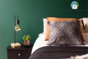 een slaapkamer met een bed met een groene muur bij Amazing Flat-Parking available-By FabAccommodation in Cardiff
