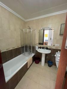 uma casa de banho com uma banheira e um lavatório em Sea View Cosy Apartment em Cabo Negro