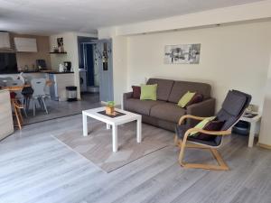 ein Wohnzimmer mit einem Sofa und einem Tisch in der Unterkunft Gîte Au Coeur Du Vignoble in Westhalten