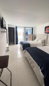 a large bedroom with two beds and a television at Blue Emerald Inn in San Andrés