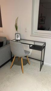 una mesa de cristal y una silla en la sala de estar. en M Apartment Loft - stylish minimalisitisch außergewöhnlich en Landau in der Pfalz