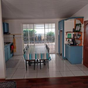 een keuken met een tafel en stoelen in een kamer bij Pacific Lodge in Mahina