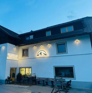 a white building with a picnic table in front of it at Landhaus Lungau in Sankt Michael im Lungau