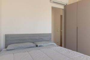 1 dormitorio con 1 cama grande y cabecero gris en Casa piccola, en Cison di Valmarino